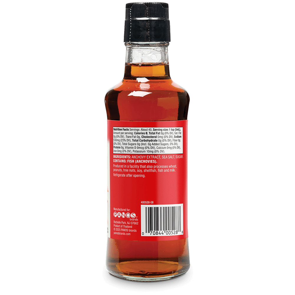 The back of a glass bottle of Anchovies Corded Fish (Anchovies) showing the red label, barcode, and nutritional information, topped with a black cap, on a white background.