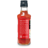 A bottle of Kame's Asian & Me Eats Sweet Chili Sauce, showing the back label and black cap on a white background.